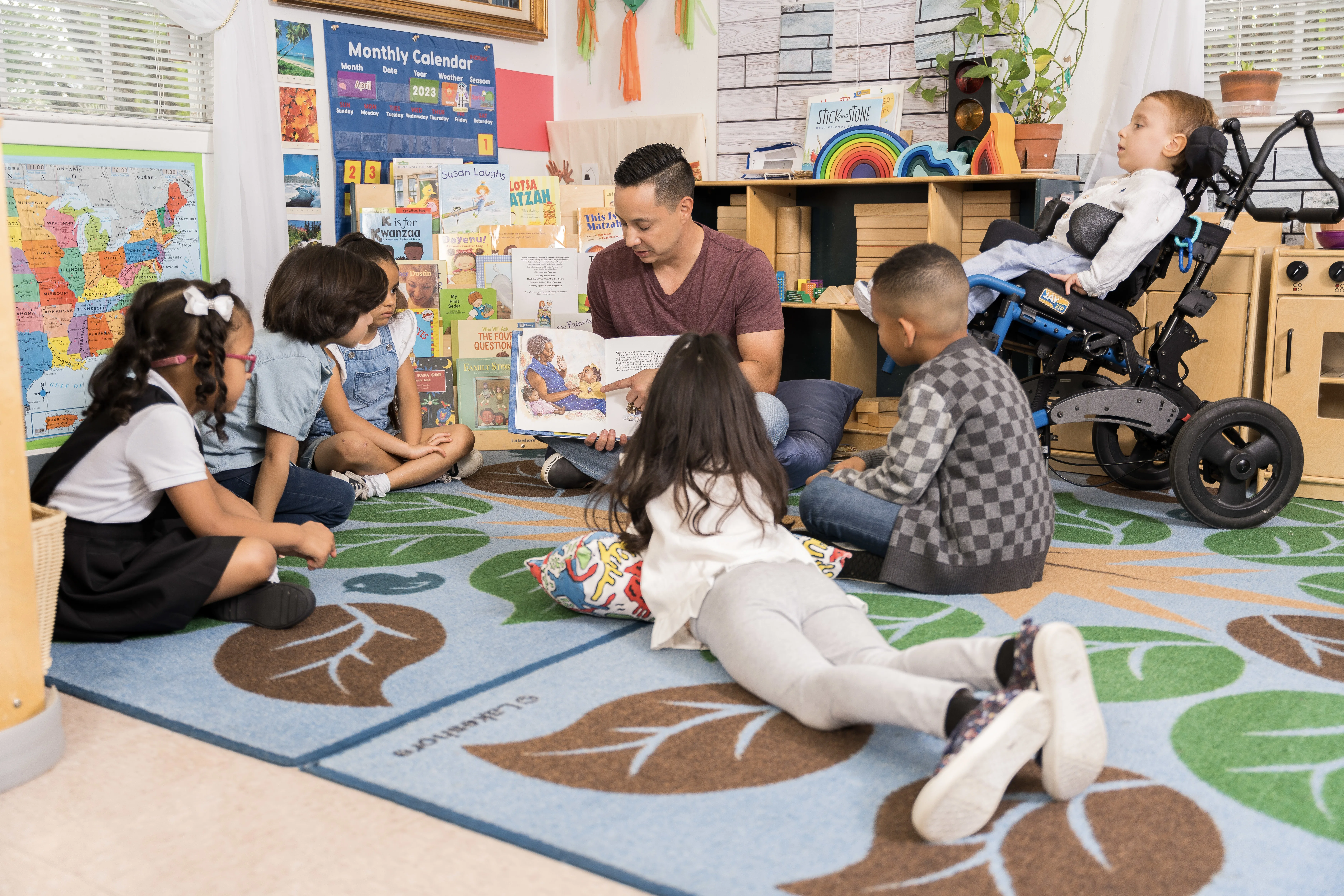 Group of children sitting on floor with a teacher