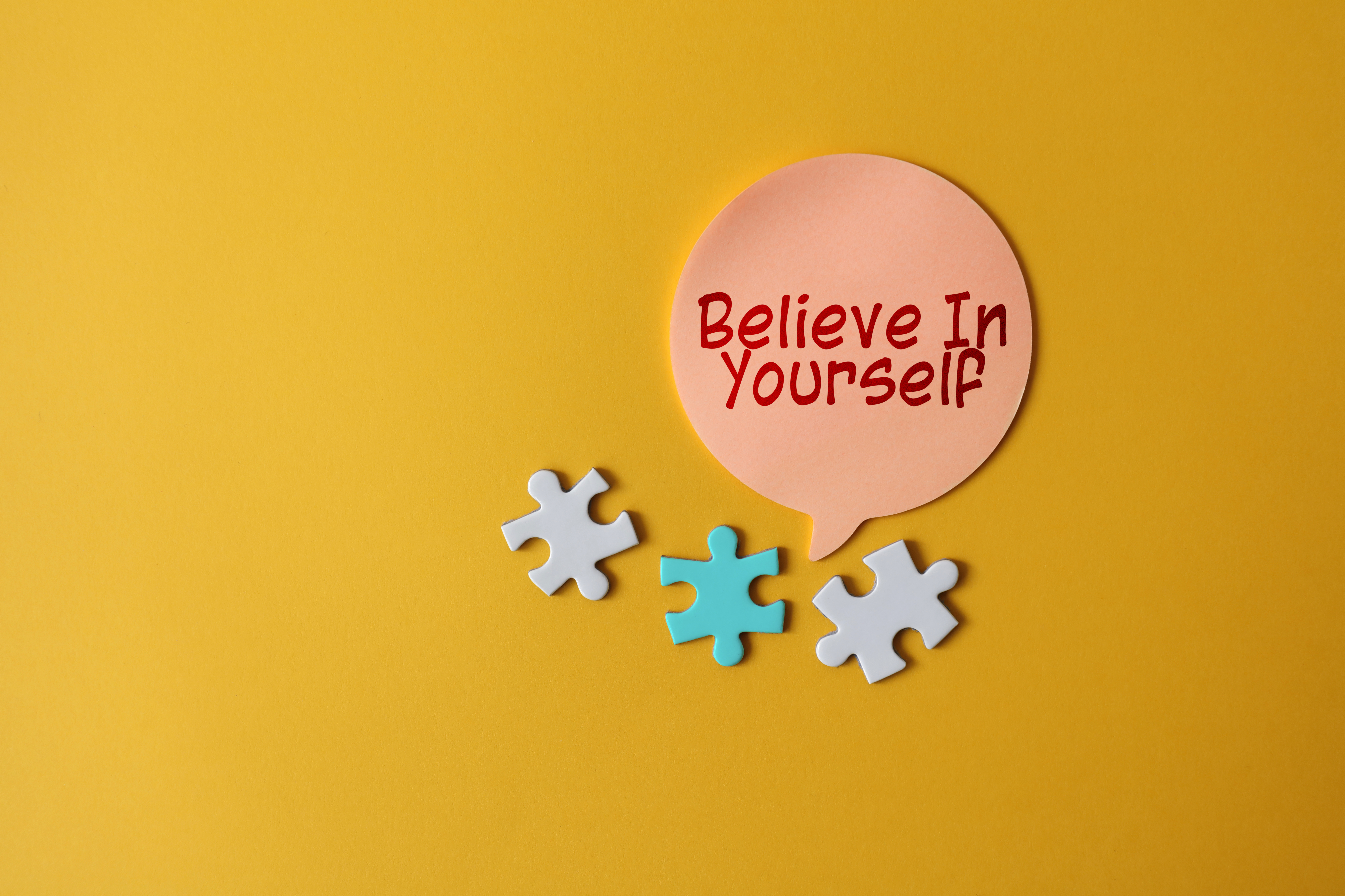 Puzzle pieces and note saying believe in yourself