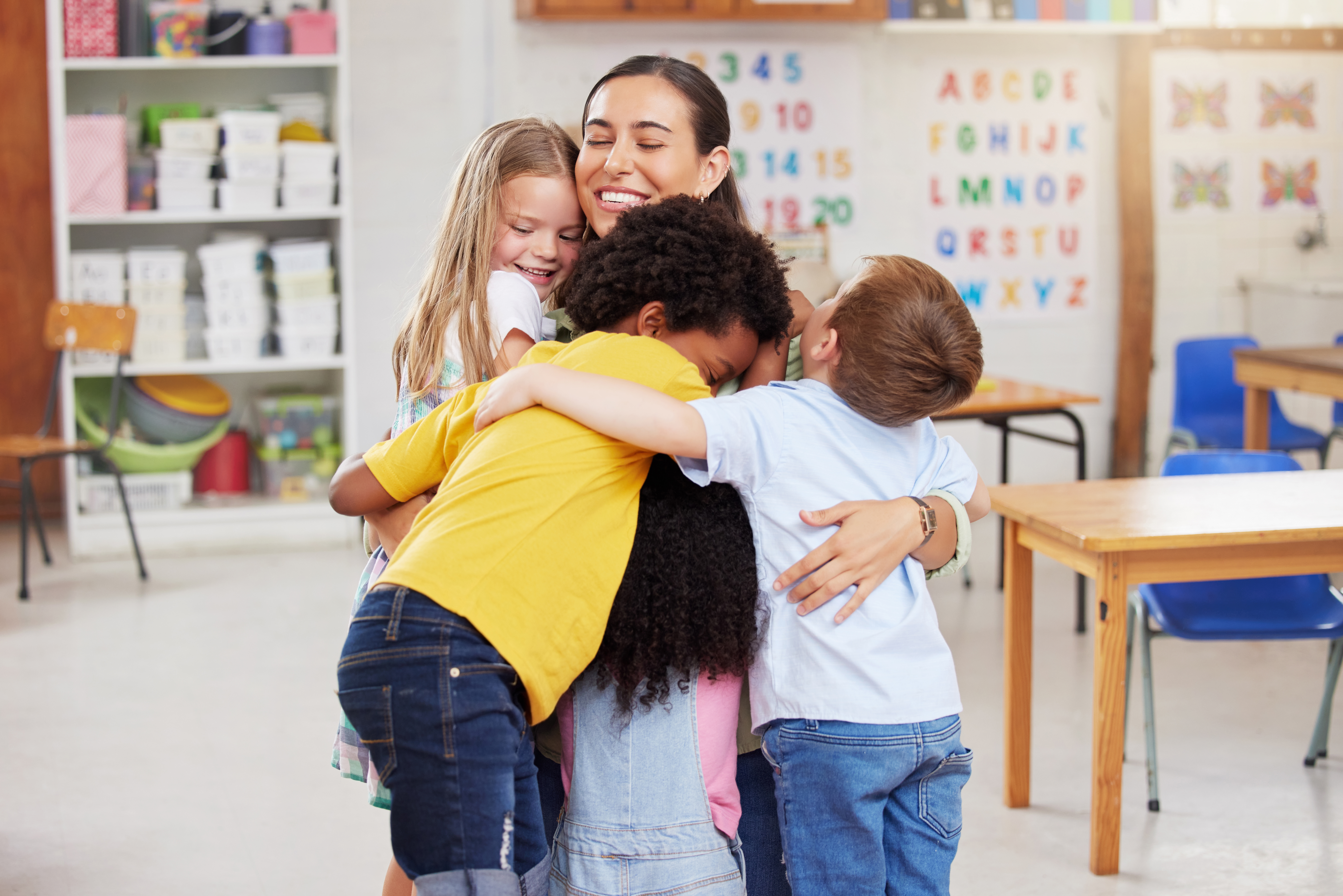 Child care worker hugging children
